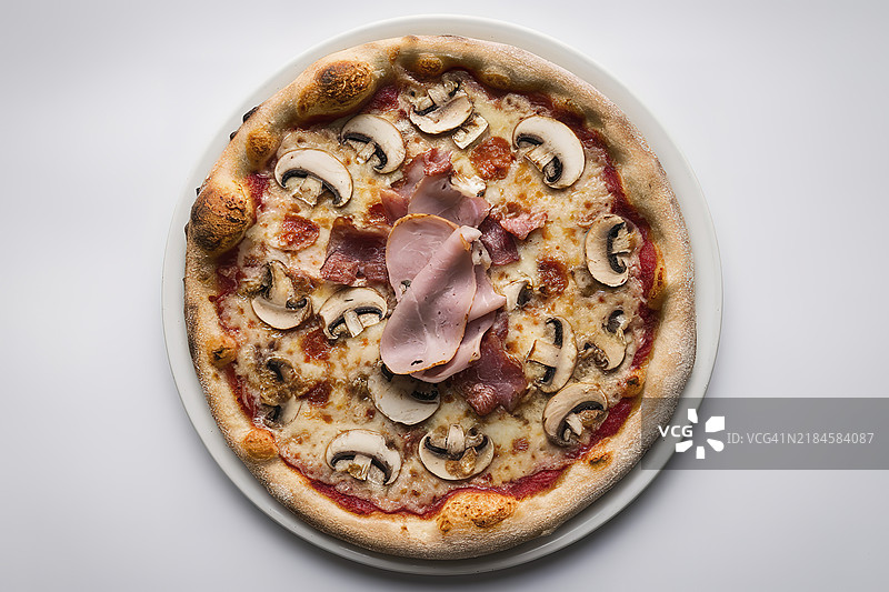 一盘新鲜出炉的披萨放在白色盘子上图片素材