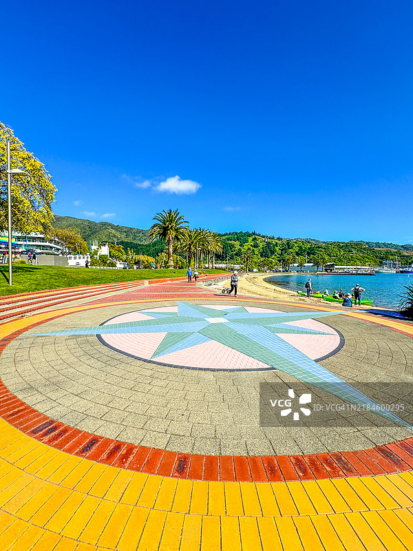 人们在皮克顿的港口边站在色彩斑斓的砖石图案旁。图片素材