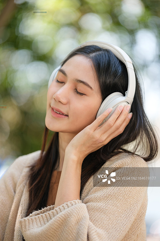 公园里微笑的女性与自行车和音乐耳机的肖像图片素材