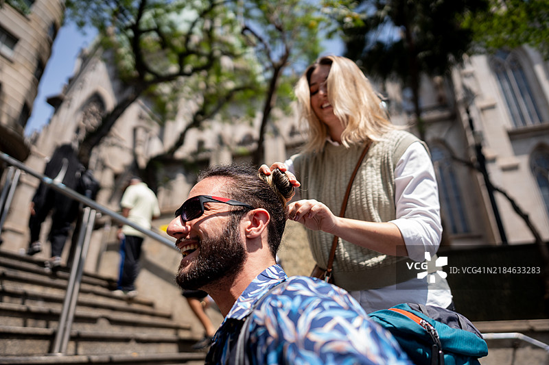 女朋友在城市里为男朋友扎头发图片素材