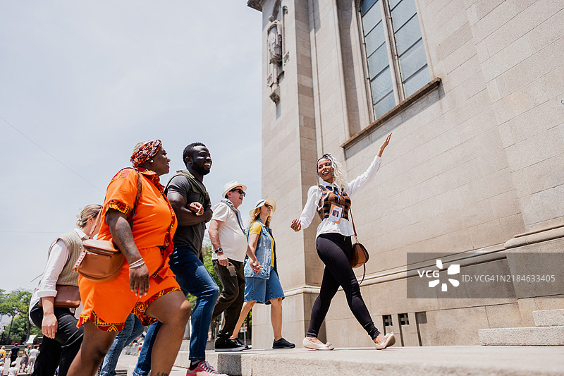 导游一边走一边向游客讲解圣母大教堂。图片素材