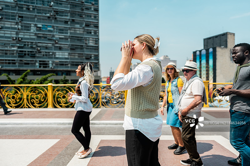 年轻女性游客在巴西圣保罗的“茶桥”上用相机拍照图片素材