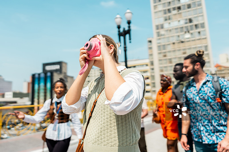 年轻女性游客在巴西圣保罗的“茶桥”上用相机拍照图片素材