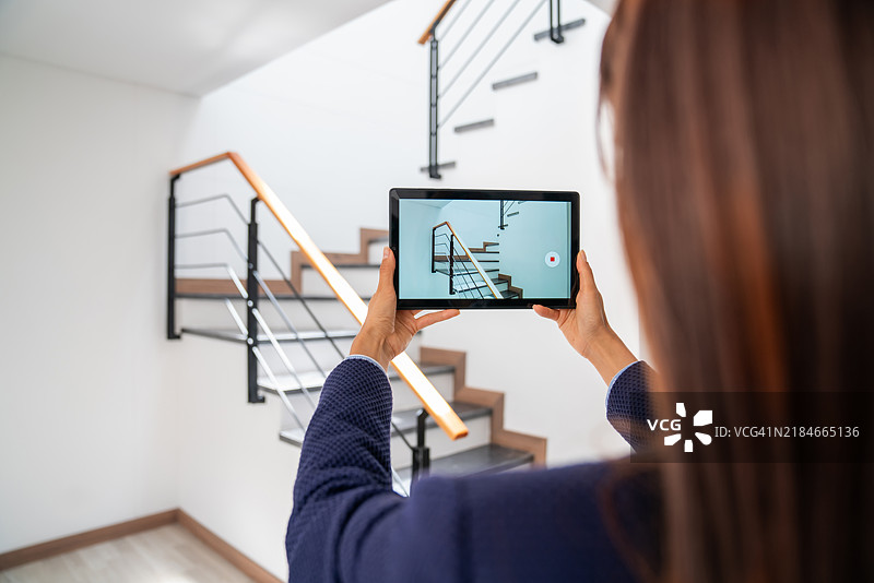 房地产经纪人在拍摄待售房屋的照片图片素材