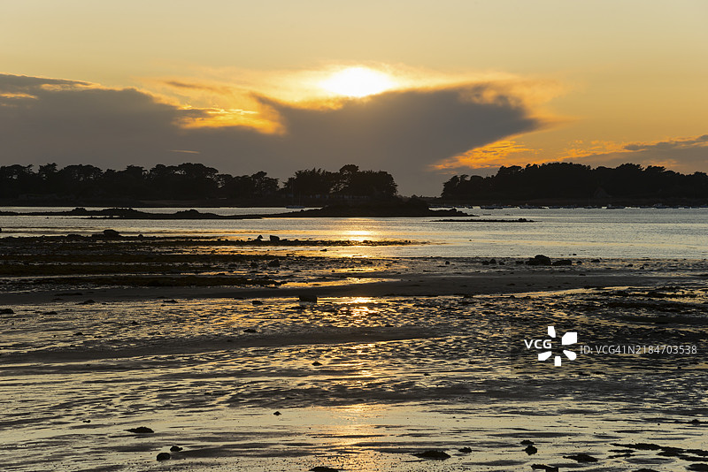 海上日落，金色倒影与海岸轮廓，拉吕泽特海滩，普卢格雷坎，阿摩尔海岸，英吉利海峡，布列塔尼，法国，欧洲图片素材