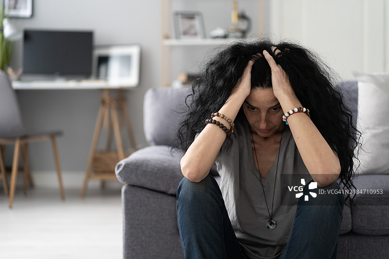 中年悲伤女性在家中遭受抑郁症的折磨图片素材