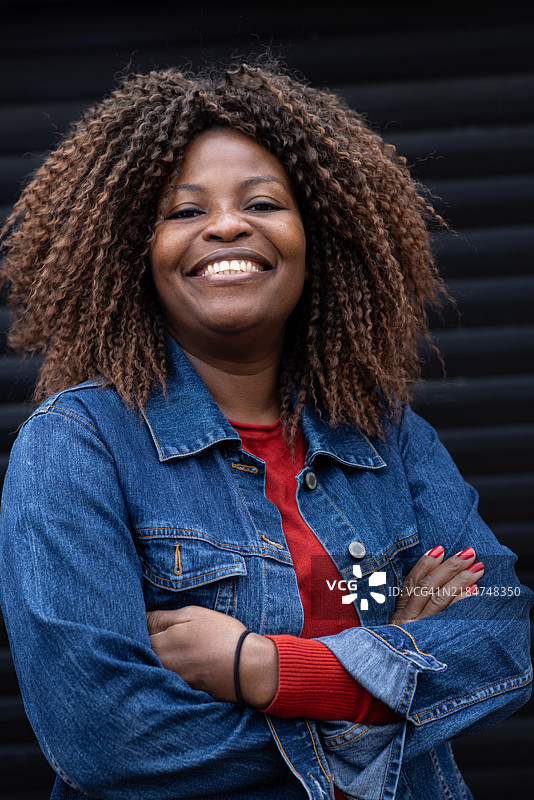 微笑的房地产经纪人双臂交叉站立图片素材