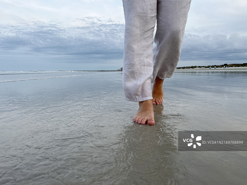 湿沙滩上脚步的特写镜头。图片素材