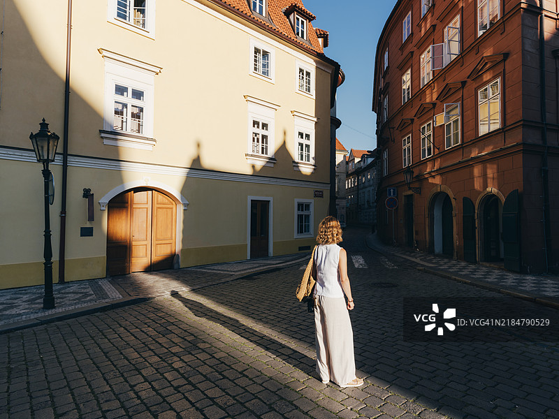 女人在捷克共和国布拉格的马拉斯特拉纳历史区探索，日出时分。图片素材