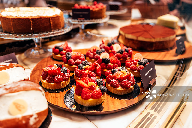 新鲜浆果装饰的甜塔在面包店展示，特写镜头图片素材