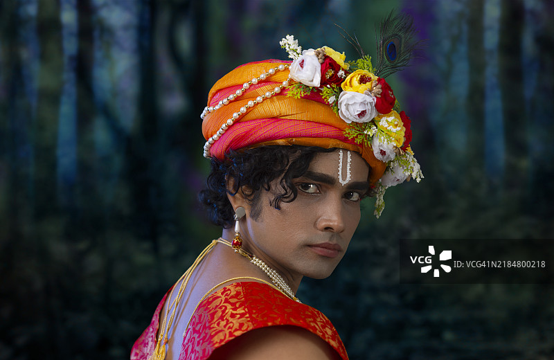 年轻男子在节日贾纳马什塔米时装扮成克里希纳的特写肖像图片素材