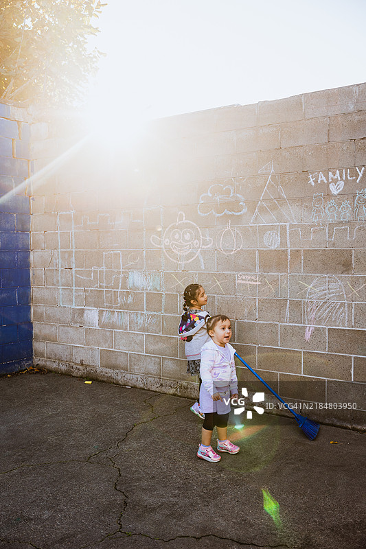 快乐的西班牙裔女孩们在院子里玩耍图片素材