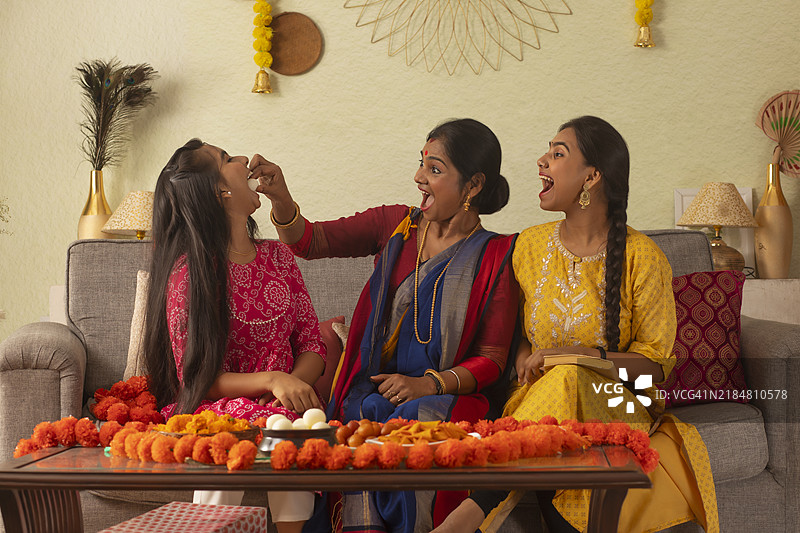 母亲在客厅里喂女儿吃拉丝古拉。图片素材