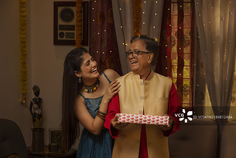 祖父和孙女在排灯节分享礼物图片素材