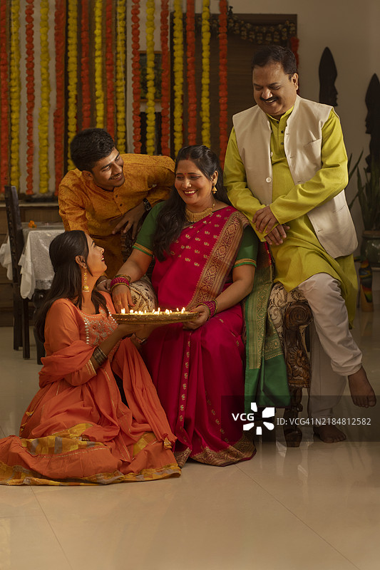 快乐的印度家庭在家中一起庆祝排灯节的肖像图片素材