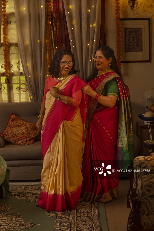 女人在排灯节帮助她的婆婆穿纱丽图片素材