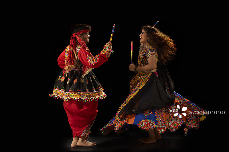 年轻快乐的情侣在纳瓦拉特里庆祝活动中表演丹迪亚拉斯舞图片素材