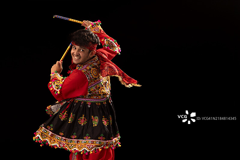 年轻男子在纳瓦拉特里庆祝活动中快乐地表演丹迪亚拉斯舞。图片素材