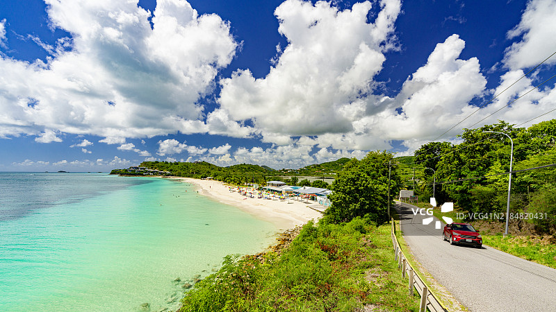 汽车在蓝色泻湖的海岸公路上行驶图片素材