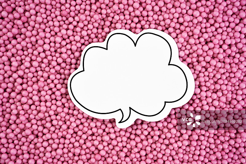 在粉色泡沫珠或聚苯乙烯球的纹理上，气泡中传达了“谈话”和“说话”这两个词，并留有空白空间。图片素材