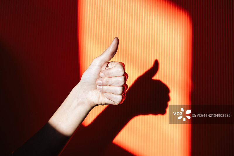 明亮背景上的“万事如意”手势。竖起大拇指的标志。图片素材