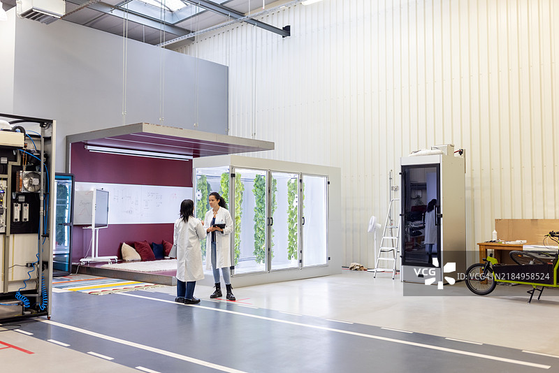 农学家在高科技垂直农场讨论植物生长图片素材