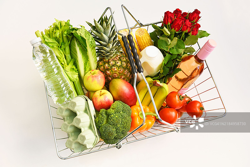 超市购物篮装有有机农产品。图片素材