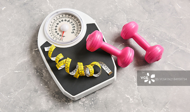 浴室秤和哑铃。图片素材