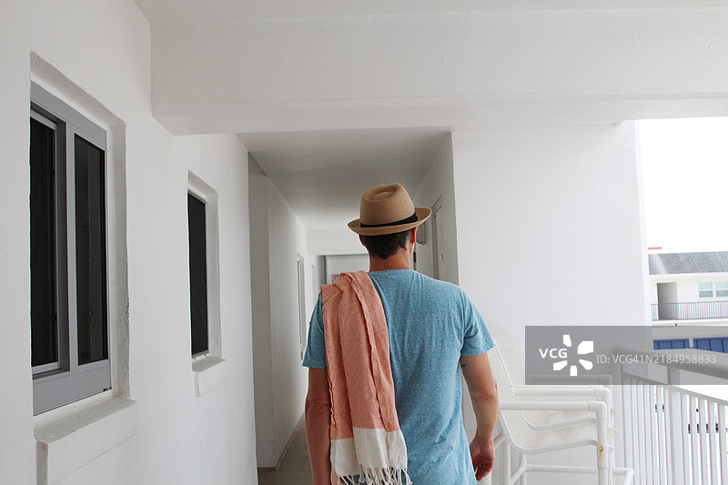 男人走在空荡荡的走廊上。图片素材