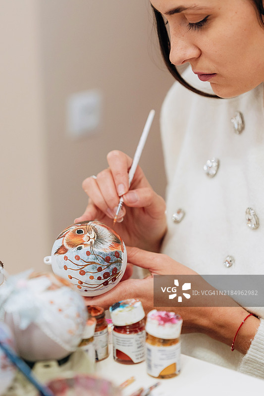 女性艺术家在家中绘制手工圣诞球图片素材