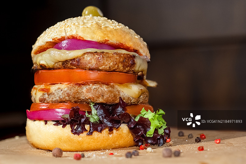 一份美味的大汉堡，上面有两个肉饼，放在调料板上，美国，USA图片素材