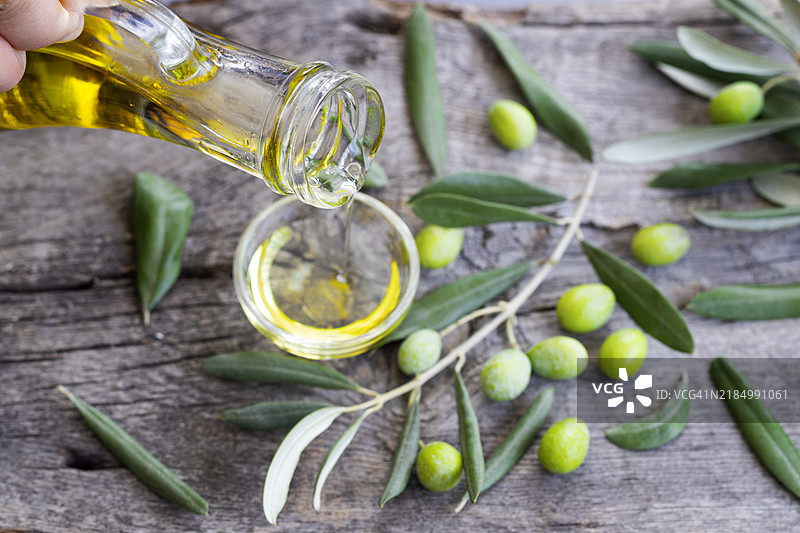高角度视图的橄榄油瓶放在桌子上图片素材