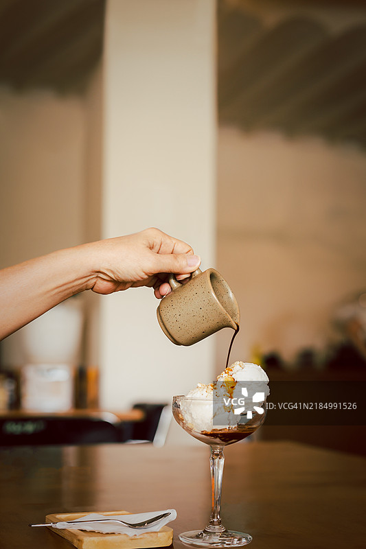 阿芙佳朵咖啡，热浓缩咖啡倒在冰淇淋上，玻璃杯放在桌子上图片素材