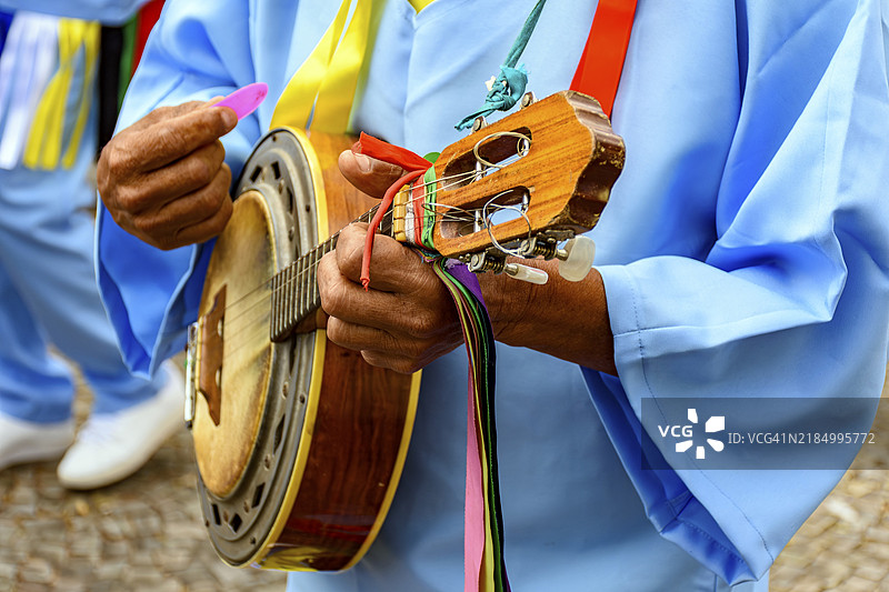 巴西贝洛哈里藏特的街头,身穿色彩斑斓衣服的班卓琴演奏者的手,参加传统宗教节日,米纳斯吉拉斯州,南美洲图片素材