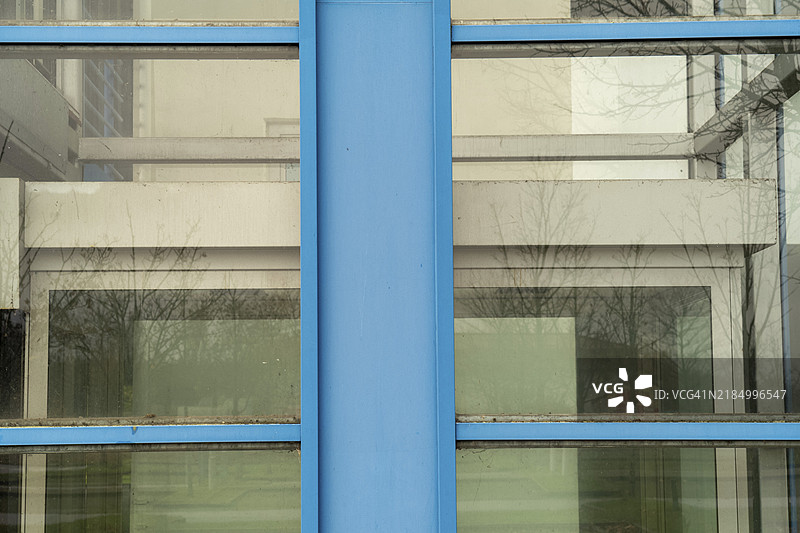 现代建筑外立面，带有蓝色柱子和反射窗户，德国北莱茵-威斯特法伦州博特罗普，欧洲图片素材