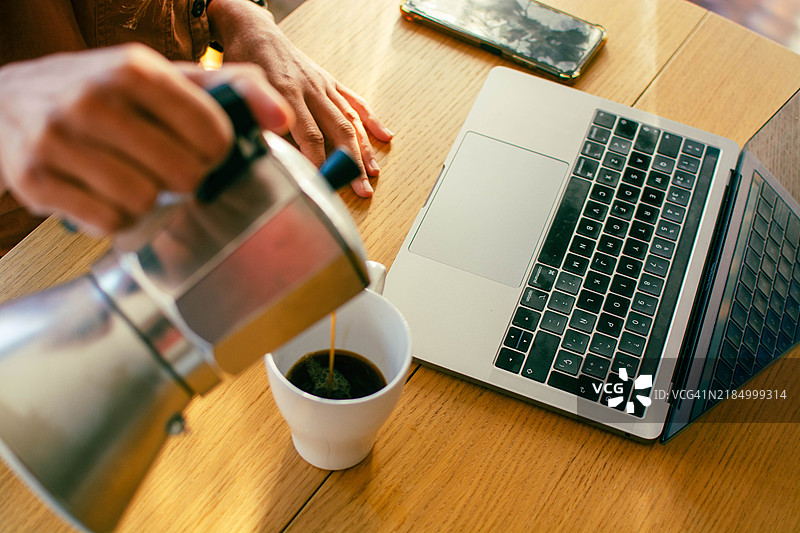 早晨开始时喝咖啡并在笔记本电脑上浏览社交媒体图片素材