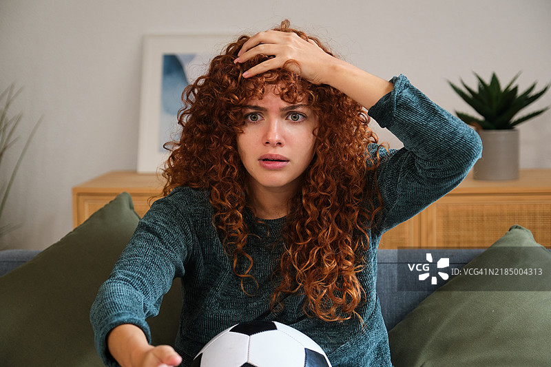 震惊的足球迷在家中观看电视足球比赛图片素材