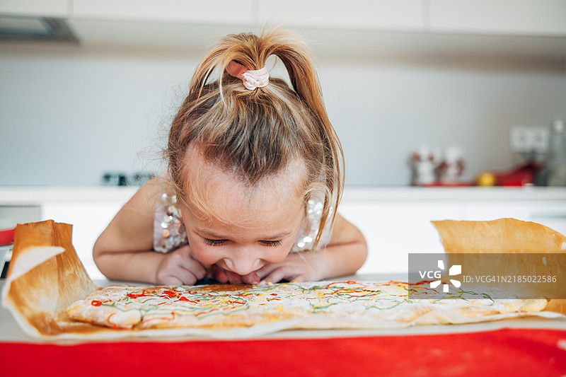 可爱的女孩尝试为圣诞节烘焙的饼干，搞笑又有趣图片素材