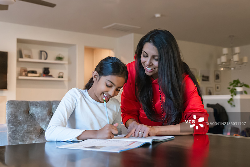 母亲在帮助女儿做作业图片素材