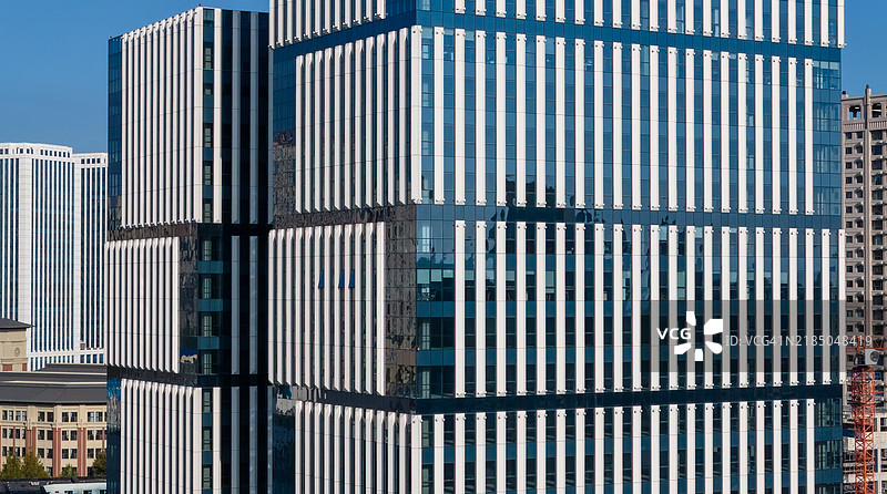 现代摩天大楼与玻璃外立面在不断扩展的城市环境中图片素材