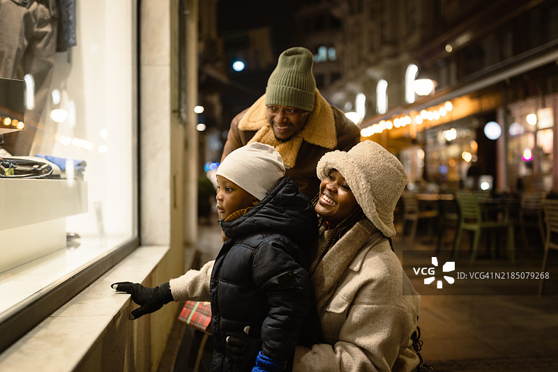 家庭在温馨的冬夜里逛街购物图片素材
