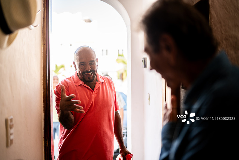 老年人到达家中并与朋友打招呼图片素材