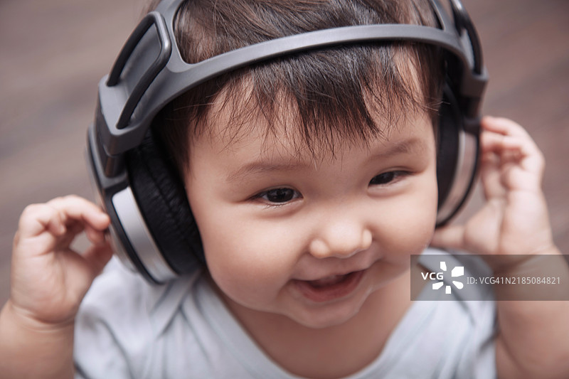 戴着耳机听音乐的婴儿（6-12个月）图片素材