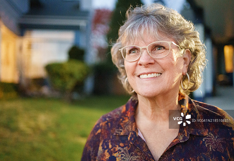 愉快的成熟的女性在黄昏时分站在户外图片素材