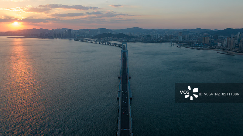 壮观的悬索桥在宁静水面上日落时分图片素材