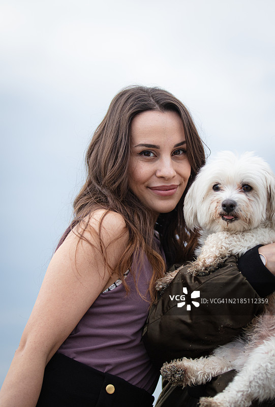棕发女性与她的小狗的肖像。图片素材