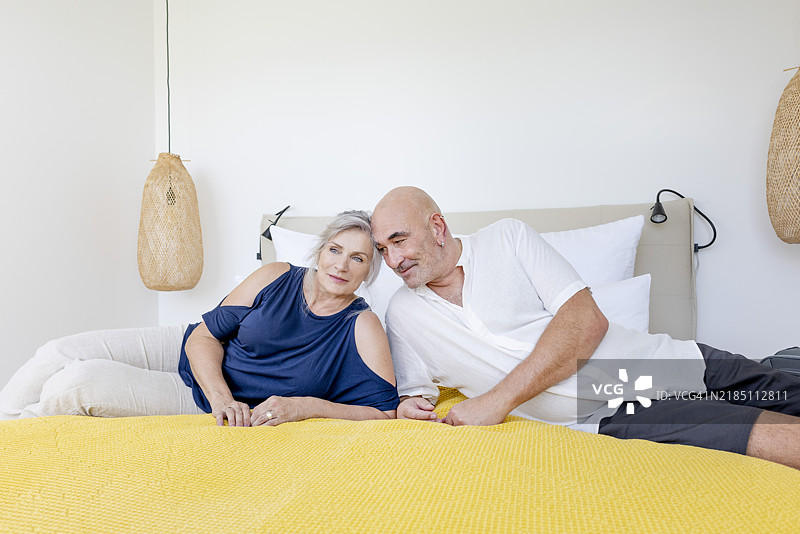 银发的最佳年龄和活跃的老年夫妇抵达度假住宿，躺在舒适的床上图片素材
