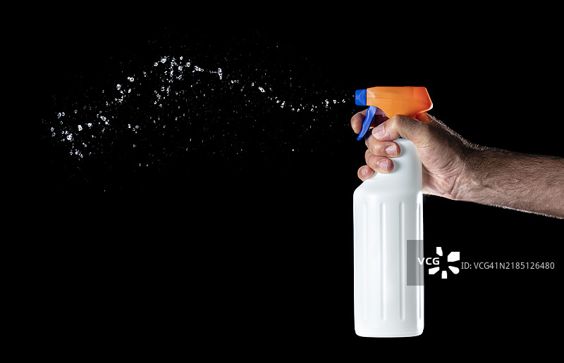喷雾瓶与清洁剂和一只男人的手在清洁。图片素材