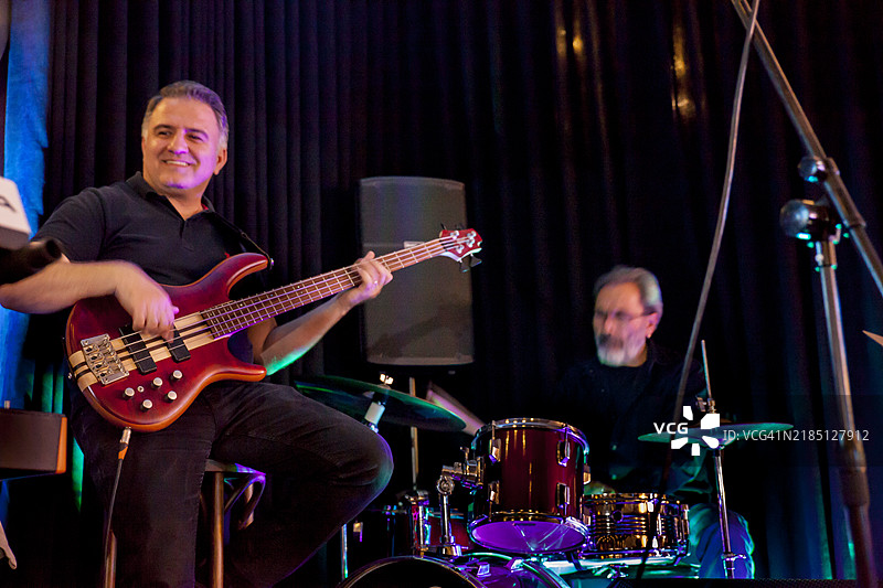 音乐乐队的贝斯吉他手和鼓手在现场表演前排练图片素材