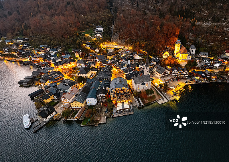 奥地利上施蒂利亚州萨尔茨卡默古特地区的哈尔施塔特村及哈尔施塔特湖的夜间航拍全景图片素材